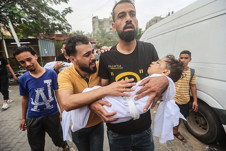 (EDITORS NOTE: Image depicts death) 
A man from the al-Aqad family holds his young nephew before the burial, who was killed in an Israeli strike on Khan Yunis in the southern Gaza Strip. The Israeli army has increased its airstrikes on targets associated with Hamas in the Gaza Strip, and they have also issued evacuation orders for Palestinian civilians to move to the southern part of the territory, despite international calls for de-escalation.