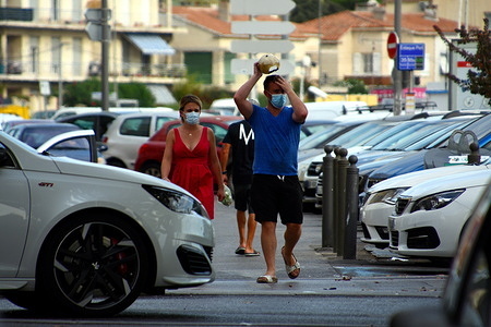 People walk through a Parking Lot while wearing face masks as a preventive measure against the spread of Coronavirus (COVID-19).
Following an upsurge in the coronavirus (COVID-19) epidemic in France, 21 departments have been classified in the red zone. The 21 departments concerned by an active circulation of the virus are Bouches-du-Rhône, Paris, Seine-Saint-Denis, Val-de-Marne, Hauts-de-Seine, Seine-et-Marne, Essonne, Val-d'Oise, Yvelines, Sarthe, Rhône, Gironde, Haute-Garonne, Hérault, Gard, Var and Alpes-Maritimes for metropolitan France. Guadeloupe, Martinique and Guyana are the three overseas territories affected by the active circulation of the virus.