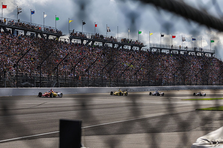 Race car driver Will Power, Scott McLaughlin, and Josef Newgarden, all of Team Penske, lead a parade lap through turn one during the 2024 Indy 500 at Indianapolis Motor Speedway.