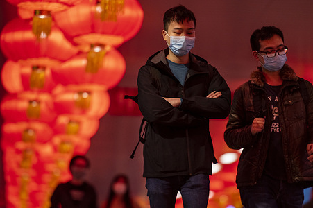 People walk through a pedestrian bridge decorated with red lanterns for the upcoming Chinese Lunar New Year of the Tiger in Hong Kong.