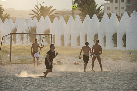 Men playing beach soccer during the sun set in Soverato.