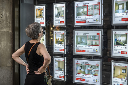 A woman wearing a mask is seen looking at the window with offers of houses and commercial premises.
The lack of tourism and the economic crisis derived from Covid-19 take their toll on businesses in Barcelona, causing the closure of commercial activity and the abandonment of premises.