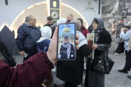 A Palestinian woman holds up a picture of her son, who is imprisoned in Israeli jails, on her mobile phone during a demonstration in the West Bank city of Nablus, demanding his release from Israeli prisons.