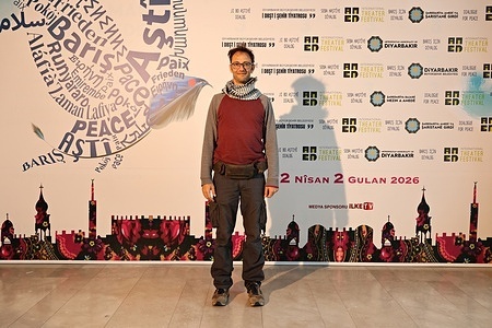Simone Romano is seen posing in front of a billboard for the 11th Amed International Theatre Festival in Diyarbakir. World-renowned Italian circus artist Simone Romano participated in the 11th Amed International Theatre Festival, organized by the Diyarbakir Metropolitan Municipality and Amed City Theatre in Turkey, and performed two shows outdoors.