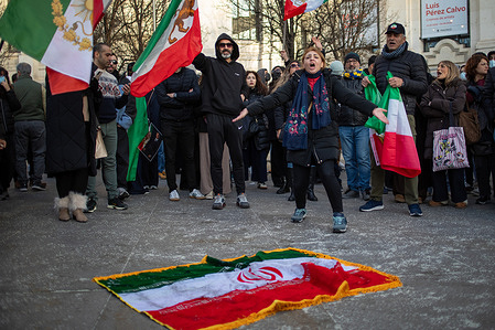 Protesters stand in front of a current Iranian flag, a symbol of the Islamic Revolution during the demonstration. A demonstration against the repression of the Iranian regime, organized by Iranians residing in Madrid, supporters of the former Shah of Iran, Mohammad Reza Pahlavi. Protests have erupted worldwide following news of deaths at the hands of the Islamic Republic regime during protests across Iran. The demonstrations stem from the worsening economic situation in the country, with an inflation rate nearing 50%, and the Iranian people are demanding change.