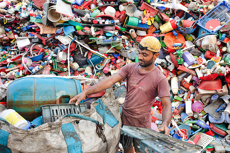 A worker seen unloading various kind of plastic materials in the yard for recycling at a plastic recycling factory. Plastic recycling factories are becoming another growing business, seeing their high demand in various kind of materials from cloths to different kind of goods. People believe its another way to save our environment.