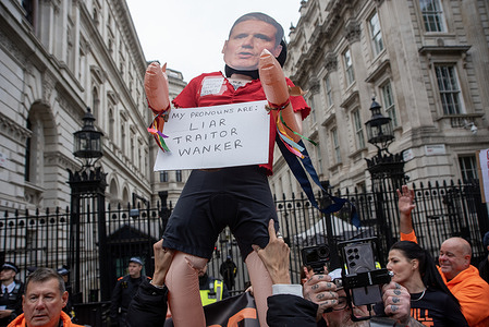 A protester holds up a sex doll with the mask of Keir Starmer outside Downing Street during the rally. Thousands of protesters marched in central London to oppose the announced digital ID plans. It is branded as BritCard, for all UK citizens and legal residents. According to the critics it will threatens civil liberties and privacy rights.