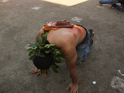 A flagellant seen kneeling down praying. Good Friday in the Philippines also known as Byernes Santo, was marked by religious custom such as carrying cross, and self-flagellation as an act of penance to cleanse their sins.