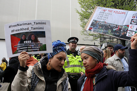 Two young women, members of Manchester's Palestine Solidarity Campaign wave protest signs whilst a policeman looks on, as they picket Barclays Bank in the city in continuing solidarity for the Palestinian cause and the Great Return March of Palestine. The demonstrators were protesting for the rights of the people of Gaza and against British Banks investment in the Israeli Arms trade and for the killings and detentions by Israeli Defence Forces of unarmed Palestinian protestors.