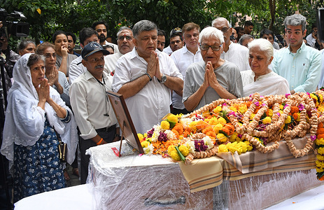 Parents (c) of Captain Sumeet Sabharwal, who died in an Air India plane crash after a takeoff at Ahmedabad's Sardar Vallabhai Patel International airport, pay tribute to their son at their residence before his mortal remains are taken for the funeral.