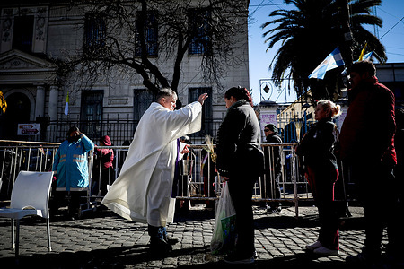 A priest bestows blessings during the celebration of San Cayetano. Every August 7th, thousands of pilgrims gather at the Shrine of San Cayetano in the Liniers district of Buenos Aires to celebrate the feast day of the patron saint of bread and work. Devotees carry small prayer cards and stalks of wheat—symbolizing daily sustenance and labor—to be blessed during open-air masses, making the date both a deep religious tradition and a prominent public display of hope for economic stability.
