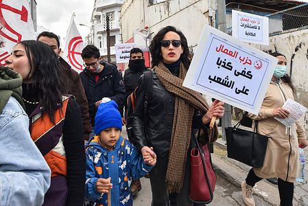 A protester holds a placard during a demonstration.
Tunisian police fired tear gas to clear hundreds of demonstrators who defied a ban on gatherings. The demonstrators gathered to protest against President Kais Saied's July power grab as the country marks 11 years since the fall of the dictator Zine El Abidine Ben Ali.
