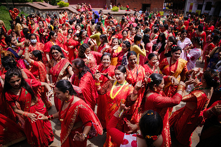 Nepalese Hindu women sing, dance, and celebrate while dressed in traditional attire during the Teej festival. During this festival, Hindu women observe a day-long fast and pray for their husbands and for a happy married life. Those who are unmarried pray for a good husband.