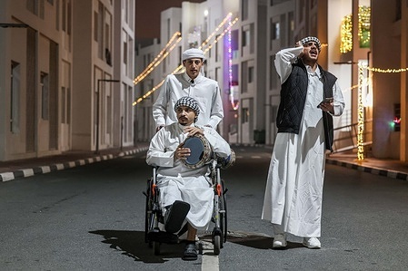 Young Palestinian men, who were wounded in Gaza are seen in Doha at midnight beating drum to wake people up for the pre-dawn meal (suhoor) in what is known as the "musahharati" during the holy month of Ramadan, inside the Al Thumama residential complex.
