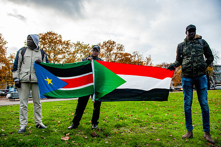 Sudanese men are seen holding flags from Sudan (right) and from South Sudan (left) during the demonstration. The Legal Committee for defending Sudanese Refugees organised a demonstration at the Ministry of Justice, focusing on the military coup that took place in Sudan in 2021 and in solidarity with the Sudanese refugees. They are in great insecurity because returning to Sudan is life-threatening for them, and because the IND (The Immigration and Naturalisation Service) has now postponed the decision on their asylum applications, so they have to wait and see whether they will ever be granted a right of residence in the Netherlands. The Committee delivered in hand a rejection note to the Minister of Justice.