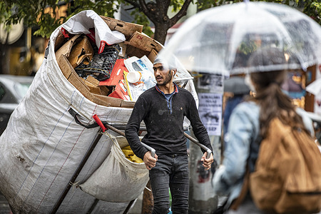 A garbage collector is seen with a wheelbarrow full of garbage in the Kadikoy district.