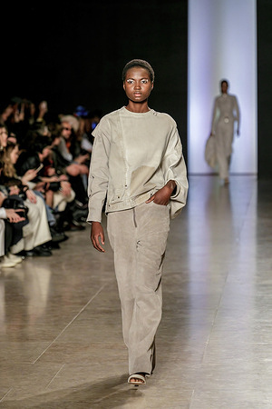 A model walks the runway at the ARNDES show during the Lisbon Fashion Week ModaLisboa, Season FW 24/25. For the FW24/25 season, Ana Rita de Sousa, the designer of ARNDES, focuses on the mundane. According to the designer, "workwear and everyday fabrics come to life in a new reinterpretation of the use of daily codes. This idea forms the basis of the collection, capturing the busyness of the day and the tranquility of the night, showcasing the balance created when wearing these everyday pieces. ARNDES is a brand dedicated to a commitment that integrates aesthetics, functionality, quality, and the impact of its products throughout their life cycle. This commitment is rooted in environmental, ecological, and social sustainability."