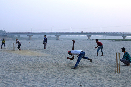 Local boys are seen playing cricket match on a drying river.
Fourteen small and large rivers flow through Dinajpur. However, almost all of them are vanishing due to lack of dredging, unrestrained river grabbers and illegal establishments. The riverbeds are now filled with silt, sediment and dust particles, causing the narrow streams to become narrower over time. Meanwhile, various crops such as Boro, wheat and corn are being cultivated on the desiccated riverbed.