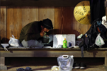 Pilgrim Koji Matsumoto, 53-years old rests at Okita Park in Kochi, Kochi Prefecture, where he sleeps outdoors and eats instant noodles as he travels the Shikoku pilgrimage route. Matsumoto says he plans to visit all 88 temples and has completed 12 so far. Pilgrims, known as “ohenro,” travel across the island of Shikoku, visiting 88 temples associated with the Buddhist monk Kukai, also known as Kobo Daishi. The pilgrimage route spans roughly 1,200 kilometers (750 miles) and can be completed on foot, by bicycle or by vehicle, passing through mountains, coastal areas and rural communities.