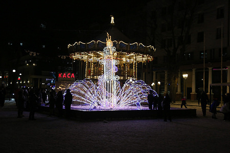 People walk near the illuminated installation on Greek Square. Odessa faces power shortages ahead of the New Year. Due to Russian shelling of the city's energy infrastructure, power outages are occurring. Despite this, residents are trying to prepare for the coming New Year.