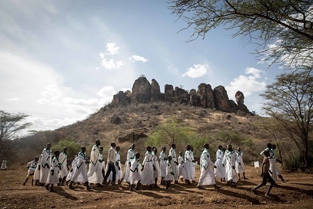 Christians from the Mafatapole church walk in front of the Kokwotom mountain in Karamoja, northern Uganda.