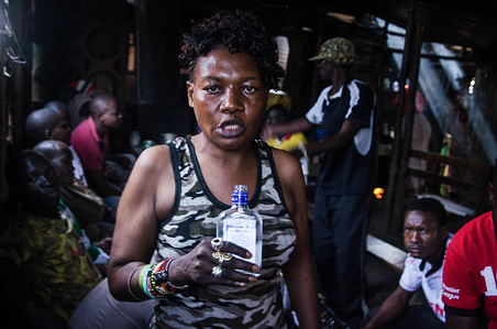 A woman seen taking alcohol at a local bar.
For a long period of time, most women from Kibera slums have been under the influence of Alcohol. Not considering the side effects, women here consume it for different reasons including taking over stress and forgetting about their family problems back home. This is due to lack of enough job opportunities and support from their husbands
The high level of alcohol consumption has led to higher rate of deaths, blindness, and risk of many dangerous diseases such as cancer, hypertension, stroke and traumatic injuries with young kids left behind as orphans. There is also unprotected sexual relations with the public and high chances of women getting raped by unknown villagers around the community leading to unwanted and repeated unstoppable pregnancies. This has led to high risk and spread of Hiv & Aids around the slums and has also left many women taking responsibilities for Kids with unknown fathers.