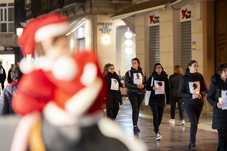 A row of demonstrators carrying candles in front of a store’s Christmas decorations. The 'Caminata del Silencio' (“Silent Walk”) is held every 24 November since 2016 on the eve of the International Day for the Elimination of Violence Against Women. Participants march in complete silence through the city center carrying candles, banners and the names of women who have been killed as a result of gender-based violence. 
The walk serves as a public call for action, demanding stronger protection measures, social awareness, and institutional commitment to end violence against women.
