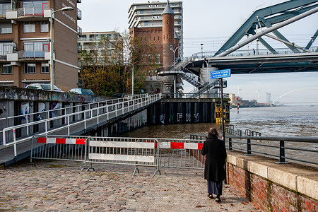 A woman is seen taking photos with her mobile phone of the flooded areas. Lower parts of the quay, and around the harbor at the Waalkade in Nijmegen, are underwater. Some farm animals were moved to higher ground. The water level right now is around 11 meters above NAP ( Normaal Amsterdams Peil). NAP is the base used to measure how high or low water levels are.