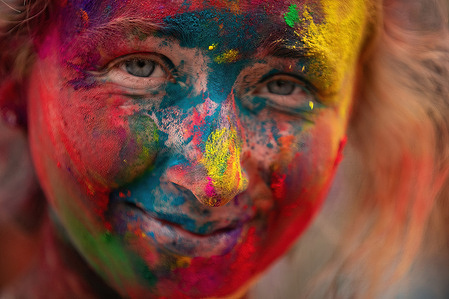 A woman's face covered with Vermilion powder seen during the festival.Holi festival also known as the Festival of Colours, is celebrated for the victory of good over evil and the coming of spring.