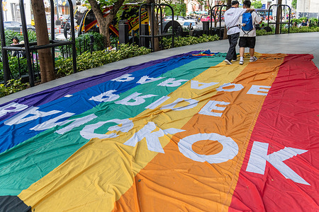 Men seen walking while holding each other on a rainbow flag of Bangkok Pride Parade 2025 on the ground at CentralWorld on Rama 1 Road. The Bangkok Pride Parade 2025 under the theme 'Born This Way' celebrates diversity across race, gender, sexual orientation and identity. The theme conveys a powerful message, Everyone is valuable. Everyone deserves respect.