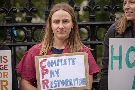 A protester holds a 'Complete Pay Restoration' placard during the demonstration. Junior doctors have been seen on strike in front of the St Thomas Hospital. Just opposite of the British Parliament. The British Medical Association is calling for a 'full restoration' of pay because of the junior doctors pay has been cut off by more than a quarter since 2008/9.