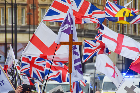 Protesters hold a Christian cross and English and UK flags during the march in Knightsbridge organised by UKIP (UK Independence Party) against Islamism and calling for mass deportations.