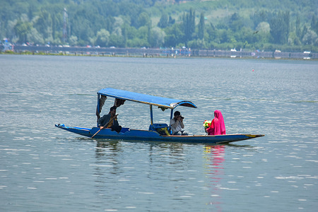 A photographer (C) takes pictures of Indian tourist (R) on a boat following the ceasefire to end the conflict between nuclear-armed neighbors India and Pakistan in Srinagar. A sense of normalcy began to return in Kashmir valley in a sign that the cease-fire that halted the most expansive fighting between the two nuclear-armed neighbors in decades. All was quiet on India’s northern and western fronts after days of air sirens and blackouts following firings and drone attacks.
