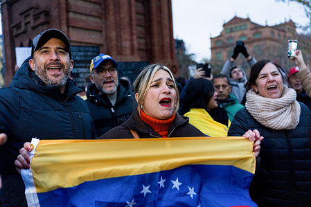 Protesters seen holding the Venezuelan flag during the demonstration. Hundreds of Venezuelan and local people gathered under the Arc of the Trionf monument to celebrate the fall of Venezuelan president Nicolas Maduro following US military intervention in Caracas.