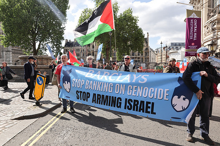 Pro-Palestinian activists hold a large banner reading "Stop Banking on Genocide" during a demonstration outside QE11 Conference Centre in Westminster, London. Protesters stage a demonstration during Barclays PLC 2025 Annual General Meeting after Barclays bank substantial financial ties with arms companies supplying weapons and military technology to Israel, used in its attacks on Palestinians. They are demanding the bank stops funding Israel's attacks on Palestinians, and are calling to boycott Barclays Bank.