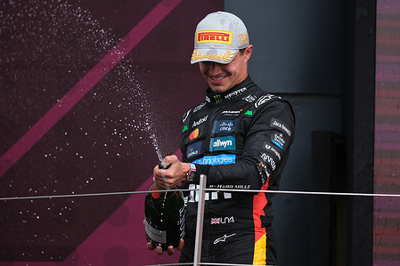 Lando Norris of McLaren F1 Team seen on the podium celebrating with champagne during the Formula One British Grand Prix at Silverstone. Lando Norris of McLaren F1 Team winner of the British Grand Prix.