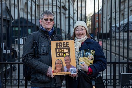 Supporters of Lindsay and Craig Foreman hold placards during a vigil calling for their release outside the gates of Downing Street. Family members and supporters of Lindsay and Craig Foreman organised a vigil on Whitehall outside the gates of 10 Downing Street in London. The couple, who were traveling by motorbike through Iran as part of a planned journey to Brisbane, Australia, are currently being detained by authorities and have been charged with espionage—a charge they both deny. Supporters are requesting increased government intervention, increased media attention, and financial contributions to assist with legal representation.