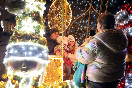 People take photos near the New Year's installation on Greek Square. The city center of Odessa is brightly decorated with illuminated New Year's decorations. Despite Russia's ongoing military aggression, people are trying to live their normal lives.