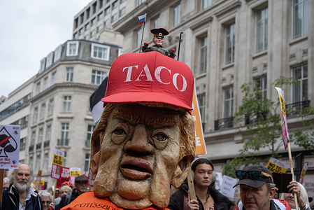 A protester wears the mask of the American President, Donald Trump with the Russian President, Vladimir Putin on the top during the anti-Trump rally. Thousands of protesters gathered from over 50 different organisations and groups outside BBC Broadcasting House to protest against the American President, Donald Trump's second state visit. The protesters marched through to the Parliament Square.