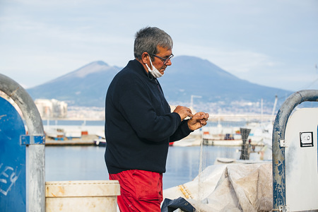 A fisherman wearing a face mask as a preventive measure, during the lockdown.
Following the covid19 pandemic that has hit Italy strongly, the Prime Minister, Giuseppe Conte has ordered strong restrictions for the quarantine to minimize the spread of the corona virus.