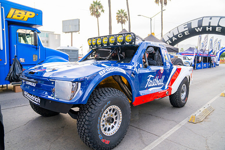 A race truck sits parked at the technical inspection area as teams make final preparations before the start of the SCORE Baja 1000. The 58th SCORE Baja 1000 took place in Ensenada, Baja California, Mexico, with technical inspections, team preparations, public activities in the downtown area, and the official race start. These images document the atmosphere around the event, including vehicle checks, mechanics at work, spectators gathering along the streets, and the first moments of the race as competitors begin the 2025 course.
