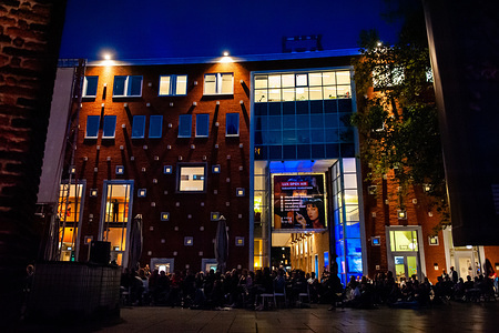 A view of the LUX cinemas, where people enjoy the outdoor cinema from.
Because the last film of Quentin Tarantino was released this month, LUX an independent and liberal platform in Nijmegen for new developments in art and culture offered an open-air cinema screenings of his well-known films, like Four Rooms and Pulp Fiction. Hundreds of people could enjoy for free the movies, like Four Rooms and Pulp Fiction in a very Tarantino style.