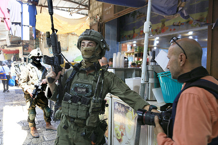 Israeli soldiers prevent a journalist from working in the middle of the market during an Israeli army raid on the city.