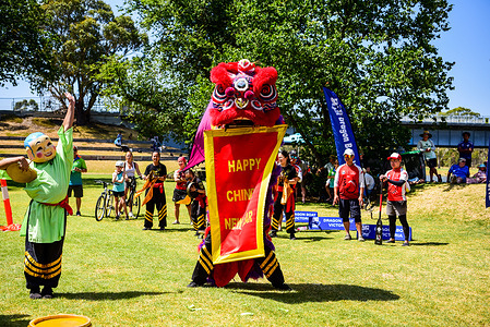 Lion dancers standing up with a banner are seen during Lion Dance presentation by Chinese Youth Society of Melbourne at Dragon Boat Lunar New Year Regatta.