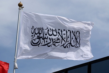 The national flag of the Islamic Emirate of Afghanistan, the Taliban, fluttering in the wind on a flagpole in Saint Petersburg, Russia.