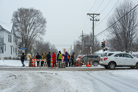 Neighbors make a blockade at an intersection designed to control the movement of Immigration and Customs Enforcement (ICE) agents in their communities. ICE agents surged into the city in January and have used aggressive tactics against protesters and citizens, including killing two - Renee Good and Alex Pretti.