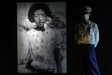 A photograph of 10-year-old Yukiko Fujii, taken after the atomic bombing seen displayed at the entrance of the Hiroshima Peace Memorial Museum. A photograph of a young girl taken on August 9,1945 three days after the atomic bombing is seen displayed at the entrance of the main building of the Hiroshima Peace Memorial Museum. Yukiko Fujii, who was 10 years old at the time and later died at the age of 42 suffered severe burns to her right arm. Her expression conveys the deep pain and sorrow of the moment. The Japanese government has recommended for UNESCO’s “Memory of the World” program a collection of photographs and film documenting the devastation following the atomic bombing. Among them is the image of Yukiko Fujii taken by the late Yukio Kunihira, a photographer for the Mainichi Newspapers.
In 2017, Yukiko’s identity was confirmed when her son, Tetsunobu Fujii, then 63 and living in Tokyo recognized the image on the newspaper’s website and came forward. The photograph has since become one of the core exhibits in the museum’s renewed permanent display unveiled in 2019.