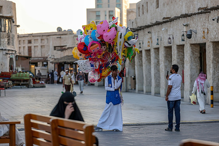 A balloon vendor walks through the Souq Waqif heritage market during the holy month of Ramadan.