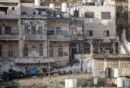 Israeli soldiers seen unloading explosives from a military truck as they surround a Palestinian home in preparation for its demolition with explosives in the Karoum Ashour neighborhood. Israeli forces demolished the home of Mahmoud al-Aqqad, who is accused of carrying out a car-ramming attack that killed an Israeli soldier on September 28 2015 at an Israeli checkpoint.