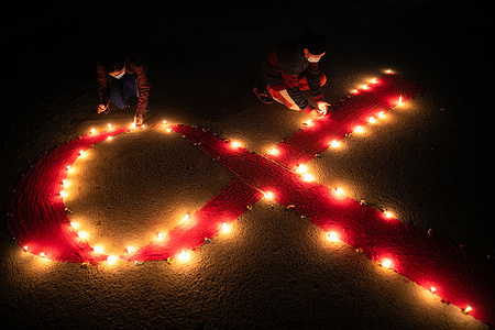 Nepalese women from "Maiti Nepal", a rehabilitation and orphanage home for HIV-affected children, women, and victims of trafficking, light candles forming the 'Red Ribbon' (recognized symbol for AIDS awareness) as they pray for those who have lost their lives due to HIV/Aids, on the eve of World AIDS Day.
World AIDS Day is observed on December 1 every year to raise awareness in the fight against HIV.